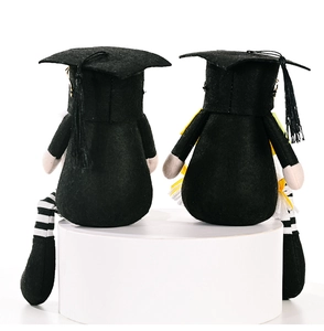 Pair of graduation gnomes in black academic caps and robes on white display stands