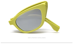 Detail of lime green cat-eye sunglasses showing portable folding frame and grey lenses