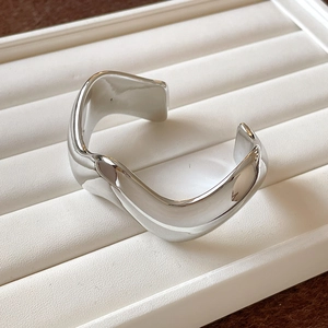 Minimalist silver wavy open bangle with polished metallic finish for women