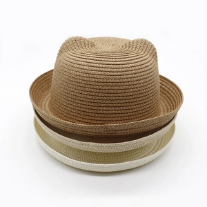 Close-up of three stacked straw hats with cute cat ears in brown, beige, and creamy white