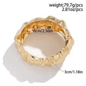 Detailed view of irregular gold bracelet with 6cm diameter and 3cm width measurements