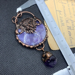 Detailed retro bronze lion head pendant with purple crystal centerpiece and irregular drop