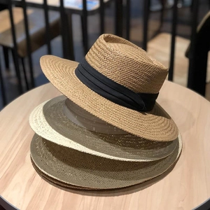 Flache Strohhüte in Khaki und Grün mit schwarzem Band für den Strandurlaub