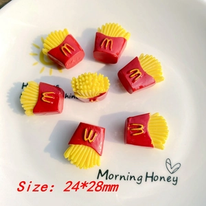 Detailed macro view of resin mini french fries charms in a white ceramic plate