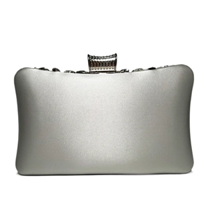 Detailed view of silver satin evening clutch with sparkling diamond-encrusted metal clasp
