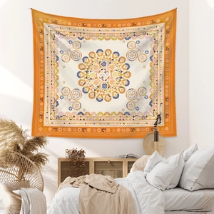 Detail of bohemian mandala tapestry featuring warm orange and cream ethnic floral patterns