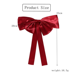 Detail showing red satin bow hair clip dimensions 20cm by 25cm with silk texture