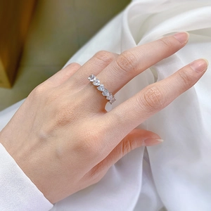 Close-up of heart-cut cubic zirconia silver ring on a model's hand with silk background