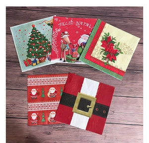 Detail of Christmas paper napkins with tree and reindeer patterns on a wooden background