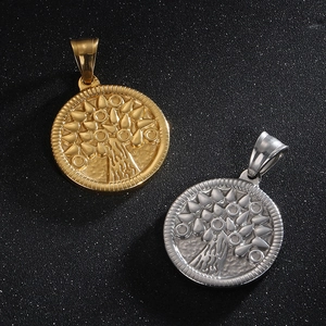 Detail of tree of life pendants in gold and silver with embossed hammered texture finish
