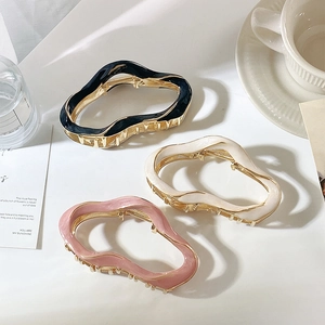 Three wavy metal shark hair clips in black, beige and pink with glossy enamel finish