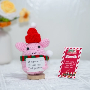 Handmade crochet pink pig with Christmas hat and motivational sign on wooden base