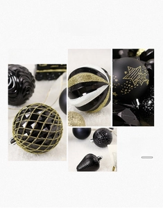 Close-up of black and gold Christmas ornaments with glitter patterns on white faux fur