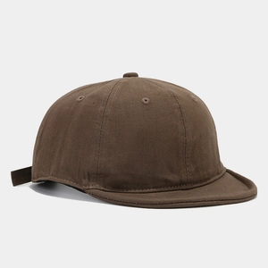 Dettaglio del cappellino marrone scuro a tesa corta con texture in cotone twill e cuciture