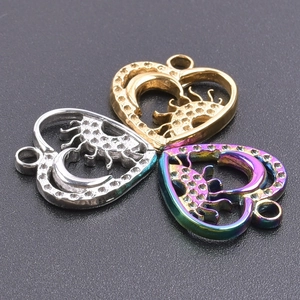 Macro shot of heart-shaped stainless steel charms with hollowed moon and star details