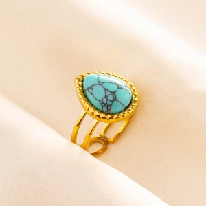Macro shot of adjustable gold-plated ring featuring a teardrop turquoise with beaded edges