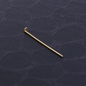 Golden stainless steel T-head pins for DIY earring jewelry making on textured background