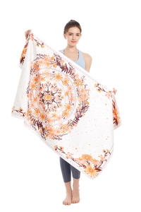 Detail of microfiber beach towel featuring a large orange floral mandala on white fabric