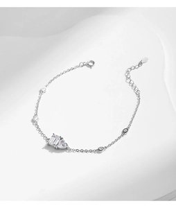 Detail view of S925 silver bracelet featuring heart and emerald cut crystal charms