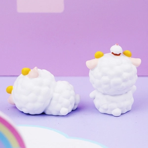Close-up of cute white resin sheep figurines with yellow horns and pink ears set of two