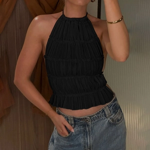 Dettaglio del crop top nero a lupetto con trama a pieghe fitte e design con schiena scoperta