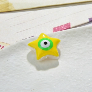 Macro view of a star-shaped yellow resin evil eye bead for DIY jewelry making