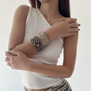 Close-up of bohemian leather wide bangles with sparkling rhinestones and metal studs detail