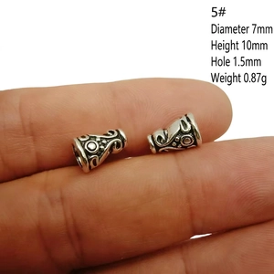 Macro shot of antique silver alloy beads with detailed engraving and dimensions