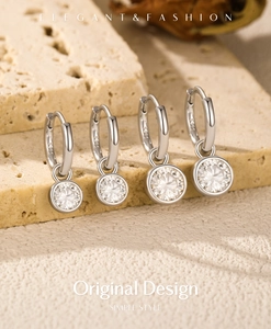 Macro shot of S925 sterling silver moissanite hoop earrings on a natural stone base