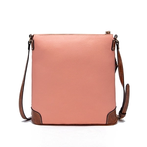 Macro detail of pink lychee textured leather crossbody bag with brown corner reinforcement