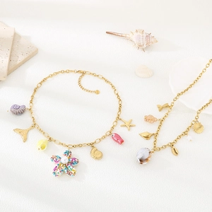 Golden ocean theme jewelry set with starfish pendants and seashells on white surface