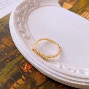 Detailed macro shot of a gold-plated geometric ring with sparkling clear zircon accents