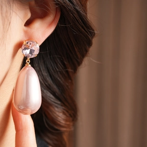 Gros plan détaillé des boucles d'oreilles en cristal rose et perle portées par un mannequin