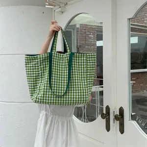 Detail view of large green and white gingham tote bag with wide durable canvas straps