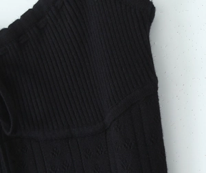Vue détaillée du tricot côtelé noir avec des motifs évidés uniques et une texture fine