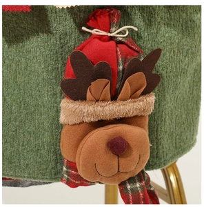 Détail de la décoration renne 3D sur une housse de chaise de Noël verte en tissu tricoté