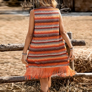 Détail du gilet en maille bohème avec motifs géométriques et longues franges au bas