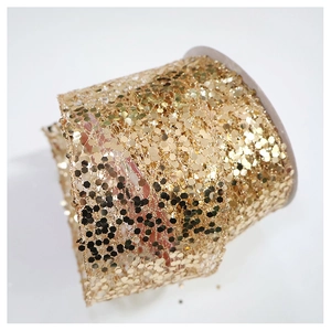 Detail of warm gold champagne sequin chiffon ribbon roll for elegant gift packaging