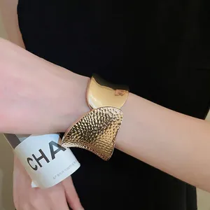 Irregular hammered gold cuff bracelet with sleek mirror finish for a minimalist chic look