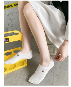 Close-up of white cotton low-cut ankle sock featuring pink floral embroidery and rib knit texture