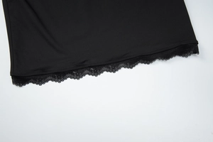 Detail shot of the black lace patchwork hemline on a bodycon long-sleeved dress