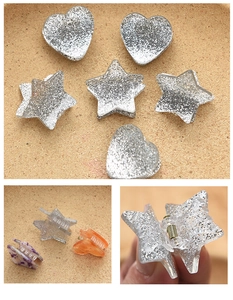 Detail shot of mini heart and star claw clips in silver glitter and marbled acrylic patterns