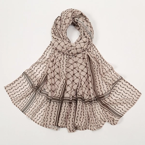Artfully folded light brown chiffon shawl with geometric patterns on a white background