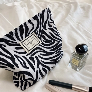 Zebra print corduroy makeup bag with PLEASANT TIME label and retro black white stripes