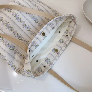 Detail of floral tote bag showing magnetic closure and spacious cream fabric lining