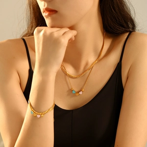 Double-layered gold necklace and bracelet set featuring colorful enamel heart charms
