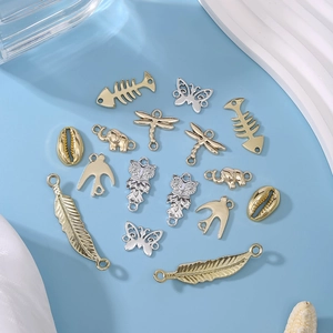 Assorted vintage alloy charms in gold and silver for DIY jewelry including butterfly and fish