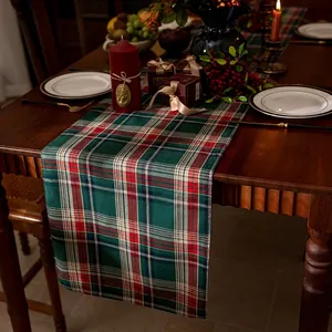Nordic red and green plaid Christmas table runner on a dark wooden festive dinner table