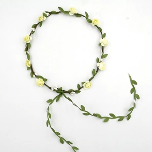 Detail of yellow roses and green leaves on a flower headband with long trailing vines