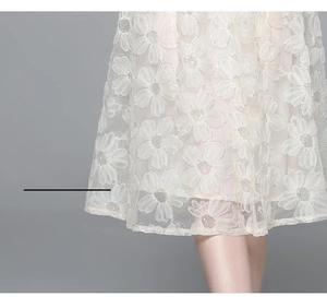Detailansicht des weißen Blumenstickerei-Spitzensaums an einem eleganten Kleid